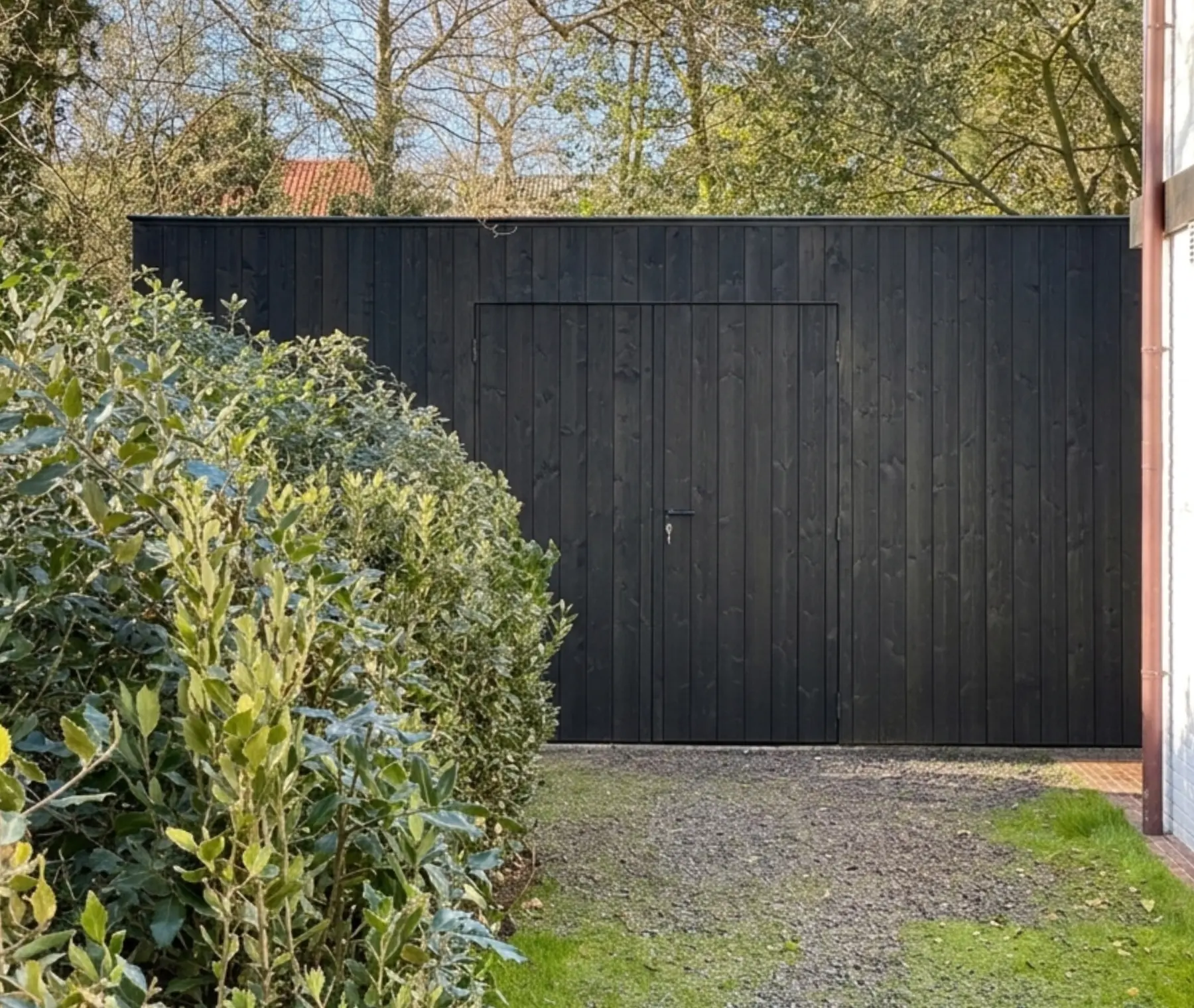 Zwarte houten tuinberging op maat in groene tuin