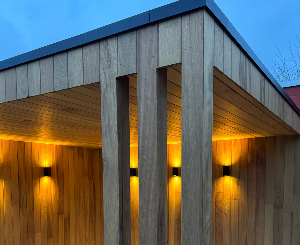 Detail van iroko gevelbekleding met sfeerverlichting bij avond