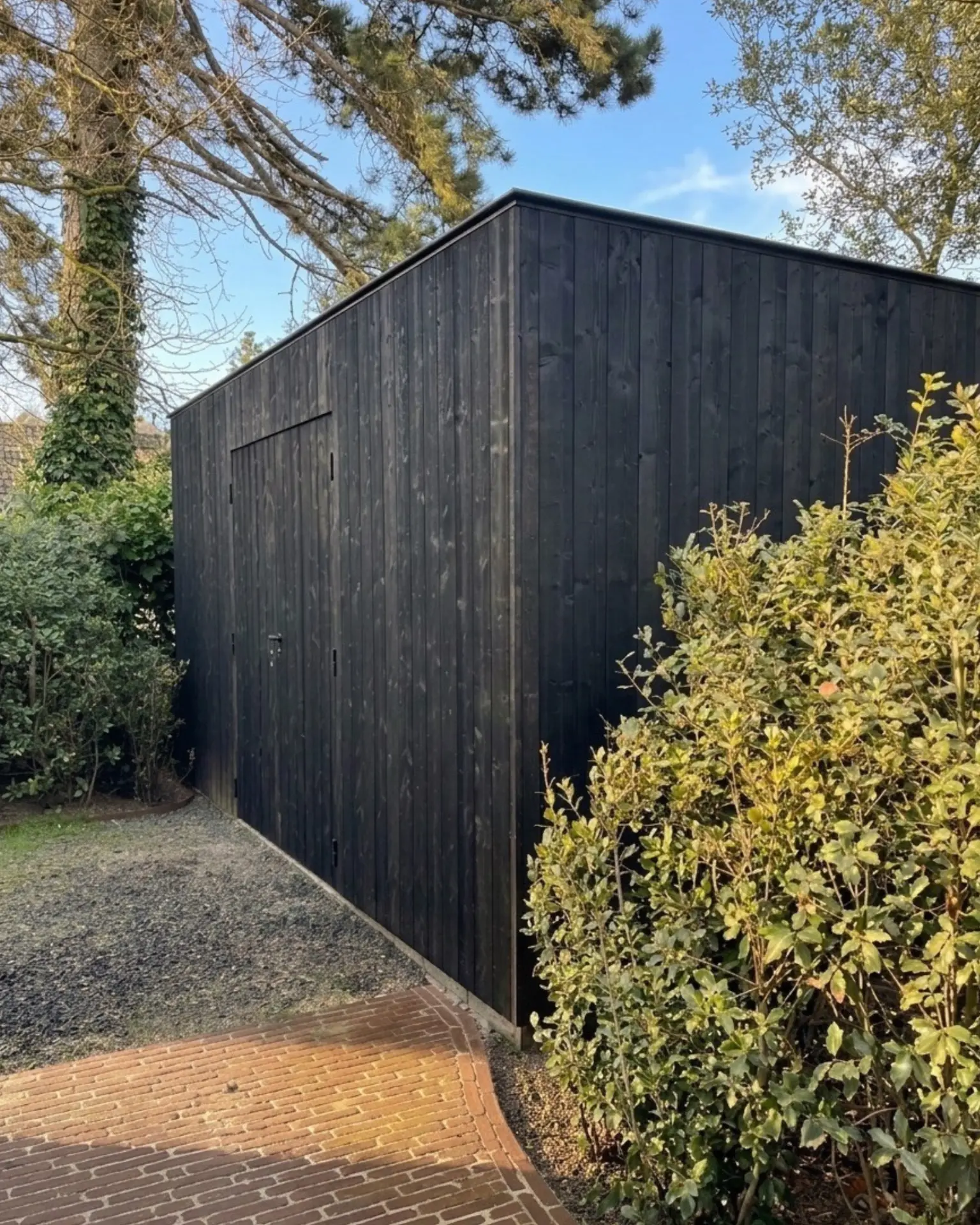 Zwart gelakte tuinberging in groene tuin