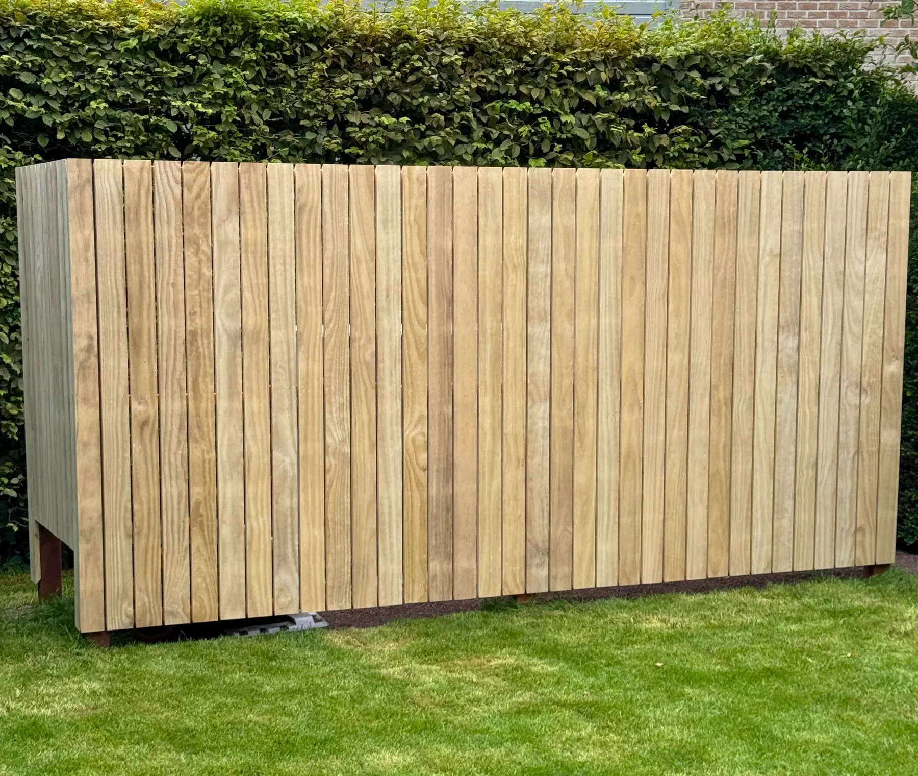 Houten gevelbekleding op maat in groene tuin