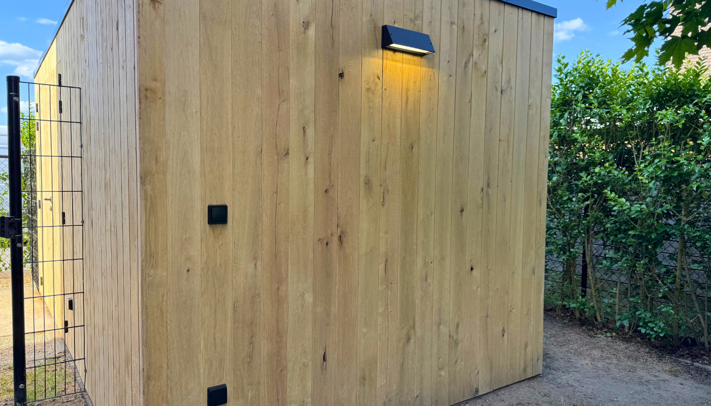 Zijgevel van eiken tuinberging met geïntegreerde buitenverlichting
