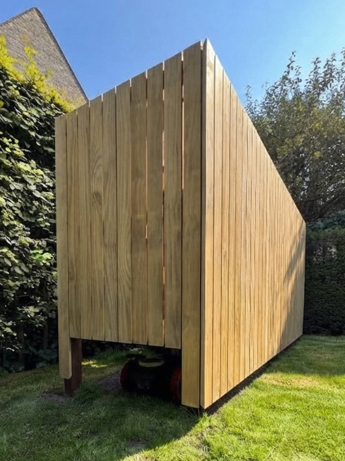 Houten beschutting voor robotmaaier op maat in tuin