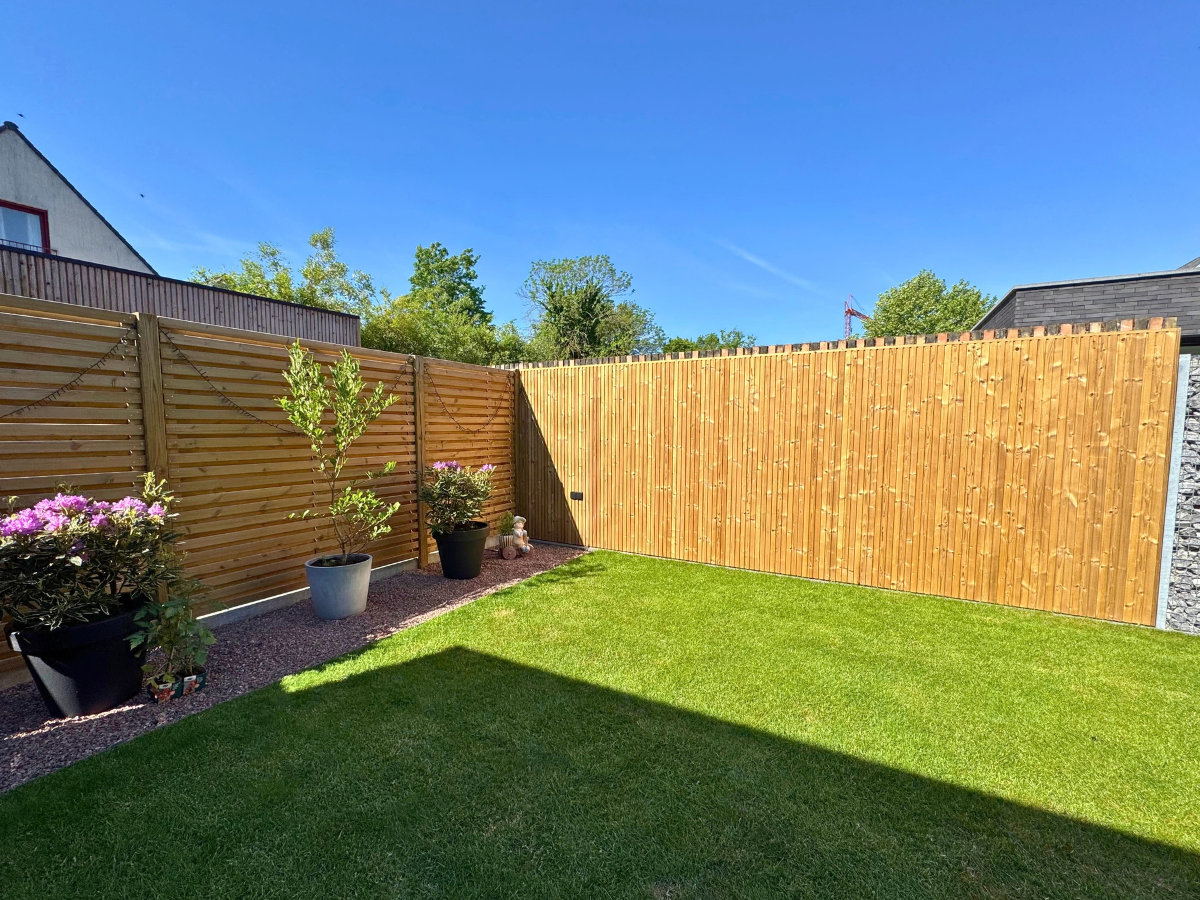 Houten schutting op maat in een groene tuin